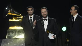 Kabir Sehgal (izq.) y Jason Carter aceptan el cuarto Grammy del exmandatario estadounidense, Jimmy Carter.