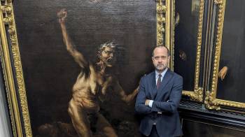 El director de la Galería de los Uffizi, Simone Verde, posa junto a la obra 'La Bruja', considerada la obra maestra de la pintura esotérica del siglo XVII, del artista maldito Salvator Rosa.