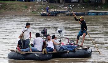 Migrantes cruzan el río Suchiate este miércoles, en la ciudad de Tapachula en el estado de Chiapas.