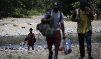 Personas migrantes cruzan el río Tuquesa en Darién (Panamá), en una fotografía de archivos. EFE/ Bienvenido Velasco