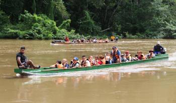 Fotografía de archivo en donde se ven migrantes que llegan en canoa por el río Tuquesa desde el poblado de Bajo Chiquito en el Darién.