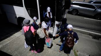 Migrantes se preparan para subir a un bus este martes, en Ciudad de Panamá. EFE/ Carlos Lemos