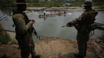 Fotografía de archivo del 9 de abril de 2024 de agentes del Servicio Nacional de Fronteras (Senafront) vigilando la llegada de migrantes que cruzan la selva del Darién.