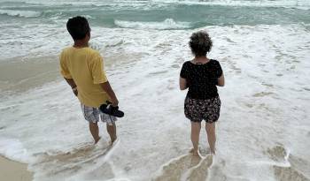 Dos personas observan el oleaje debido a la proximidad de la tormenta tropical 'Beryl' este sábado, en Cancún (México).