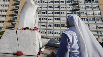 Una monja reza ante una estatua del Papa San Juan Pablo II fuera del Hospital Universitario Gemelli, donde el papa Francisco.