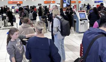 Pasajeros de al aerolínea Jetstar en el aeropuerto de Gold Coast in Bilinga (Australia) esperan frente frente a los mostradores cerrados debido al apagón global de varios sistemas informáticos.