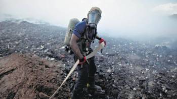 Imagen de personal idóneo sofocando uno de los incendios en el vertedero.