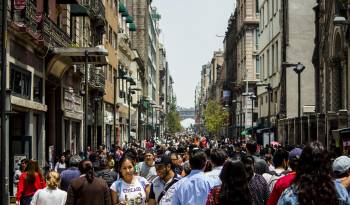 Citadinos y turistas que caminan por una avenida de la ciudad de México