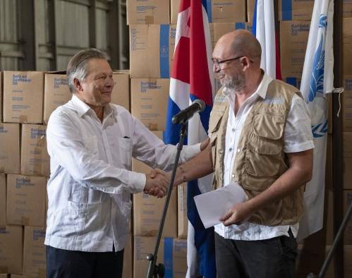 Etienne Labande (d), representante del Programa Mundial de Alimento (PMA) en Cuba, saluda a Victor Koronelli (i), embajador de Rusia en Cuba, durante la ceremonia de recepción de aceite vegetal donado por la federación Rusa, hoy, en La Habana (Cuba).