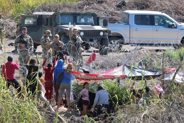 Migrantes son retenidos por La Guardia Nacional estadounidense al cruzar el Río Bravo para intentar ingresar a Estados Unidos hoy, en Matamoros