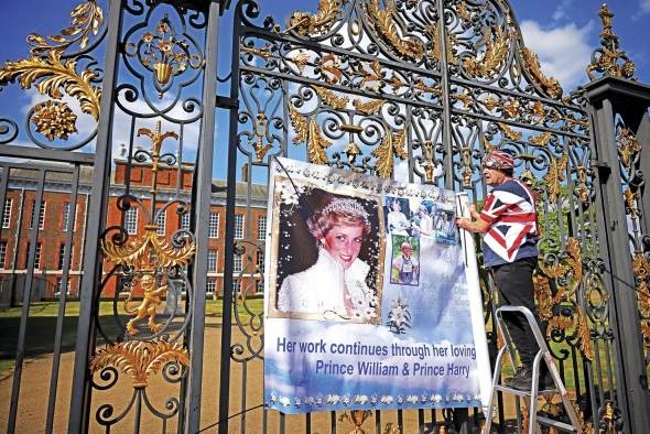 Fan coloca un póster de la princesa en la puerta del palacio de Kensington en Londres