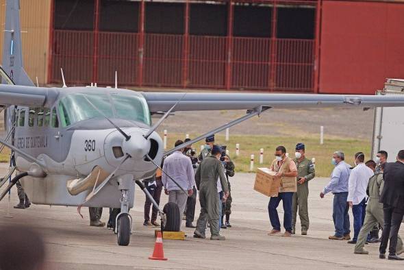 Autoridades hondureñas cargan a un avión de la fuerza aérea de Guatemala con las vacunas donadas por Israel.