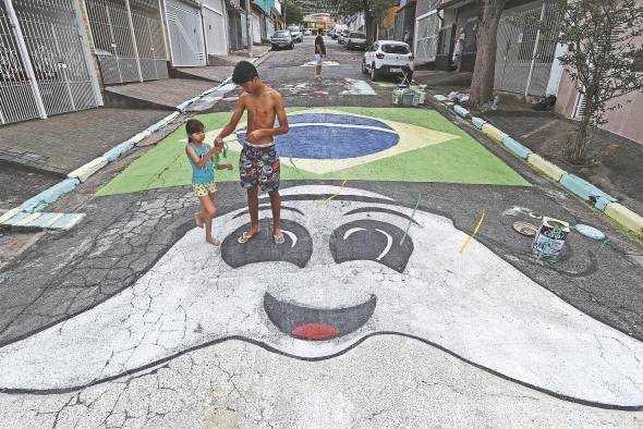 Los brasileños pintan una calle con los colores verde y amarillo.