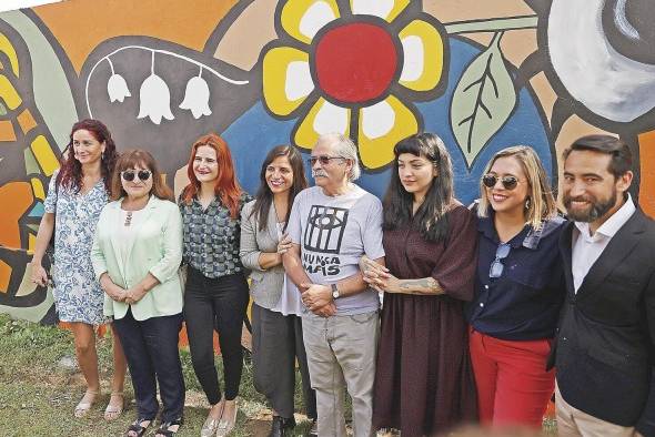 Los artistas Mon Laferte (3d) y Alejandro “Mono” González (c) posan junto a otras personas durante la inauguración de su mural.