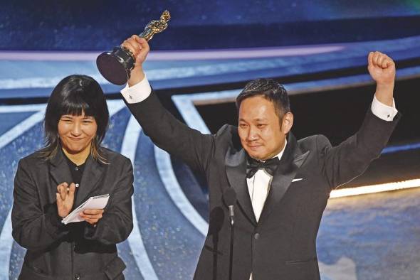 El director japonés Ryusuke Hamaguchi (der.) recibió la estatuilla a Mejor película internacional por 'Drive my Car'.