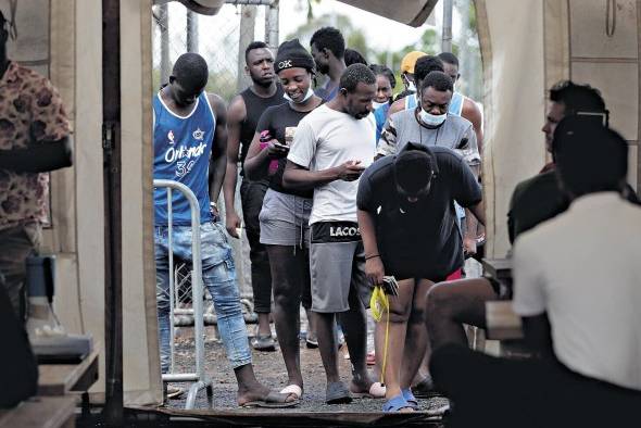 Migrantes hacen fila para registrarse en el albergue de San Vicente en Darién