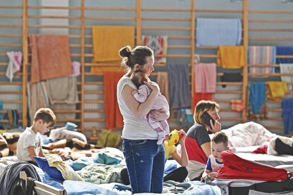 Una mujer sostiene a su bebé de dos meses en un refugio temporal ubicado en un gimnasio de una escuela secundaria en Przemysl, cerca de la frontera entre Ucrania y Polonia.