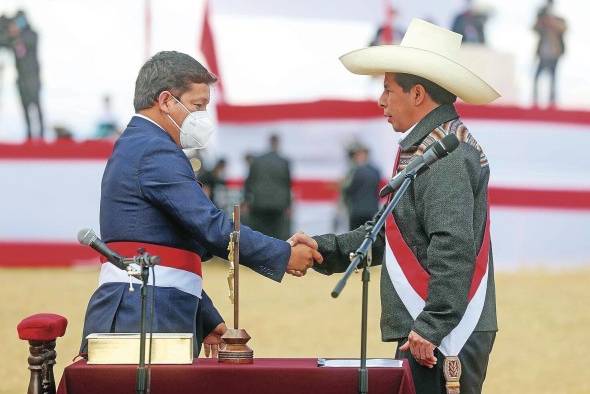 El recién investido presidente peruano Pedro Castillo (d), mientras celebra con Guido Bellido luego de elegirlo como primer ministro de su gobierno.