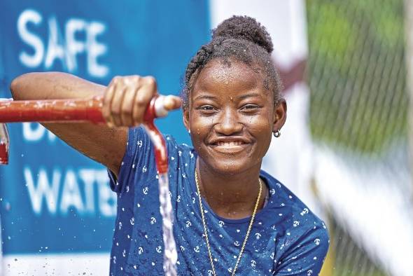 Una adolescente hace uso del suministro de agua potable que Unicef y sus socios brindan en la ERM de Lajas Blancas, Darién.