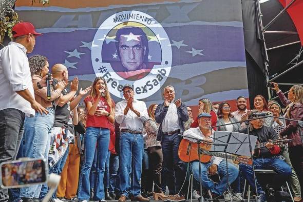 Camila Fabri (camisa roja), esposa de Alex Saab, y el presidente de la Asamblea Nacional de Venezuela, Jorge Rodriguez (c) en una concentración en apoyo al empresario.