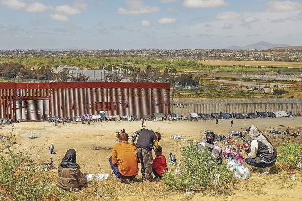 Migrantes detenidos son llevados por miembros de la Patrulla Fronteriza estadounidense a un vehículo, junto al muro fronterizo en El Paso, Texas (EE.UU.).