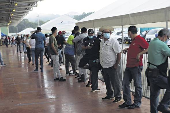 Panameños esperan la aplicación de la vacuna anticovid.