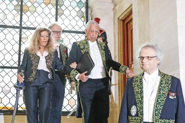 El escritor peruano desciende las escaleras acompañado de la escritora francesa Barbara Cassin en la Academia Francesa.