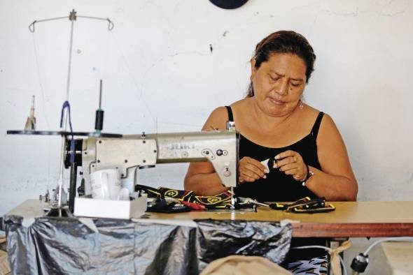 Una mujer trabaja este martes en un taller de confecciones en San Salvador (El Salvador)