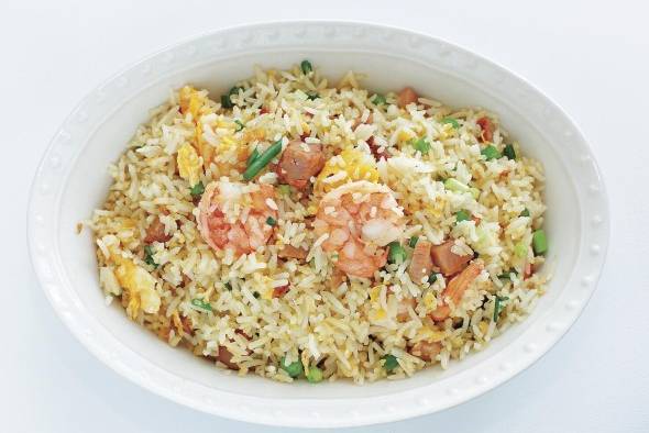 Arroz young chow. En lugar del popular arroz frito, pida esta versión que no está teñida con la salsa de soya pero cuyos otros ingredientes así como la cocción en el wok aportan ricos sabores