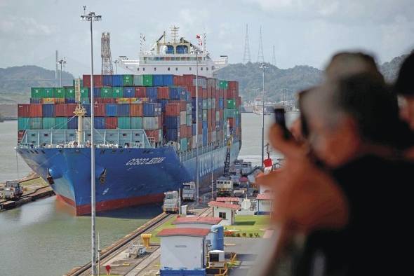 Turistas observan el tránsito de un buque portacontenedores en el Canal de Panamá, en una fotografía de archivo.