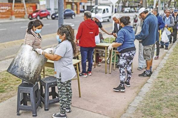 Fotografía de archivo de personas en situación de calle que reciben comida en Buenos Aires (Argentina).