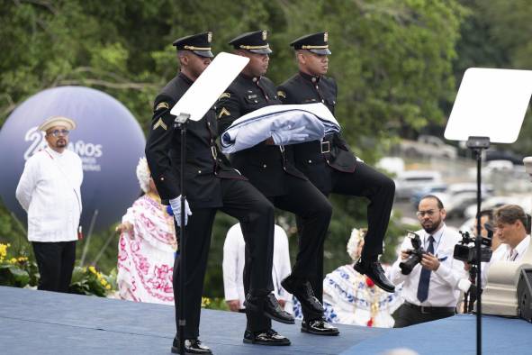 Cadetes marchan con la bandera de Panamá en la ceremonia conmemorativa por los 25 años de la transferencia del Canal de Panamá este martes, en el edificio de la Administración del Canal en la Ciudad de Panamá.