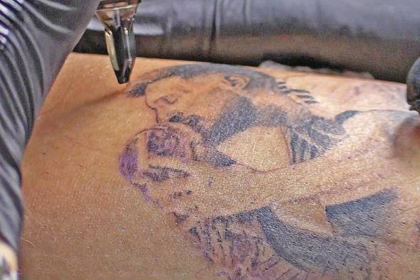 Una persona se hace un tatuaje de Messi besando la copa.