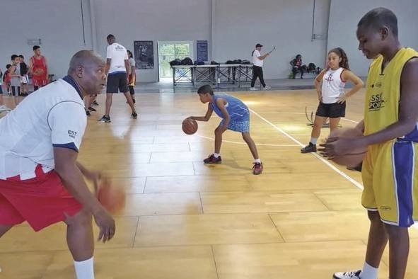 Duncan le enseña a uno de los estudiantes el secreto de dominar el balón ('dribling'), mientras lo va picando y avanzando.