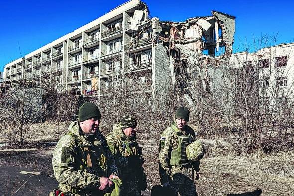 Varios soldados ucranianos caminan frente a un edificio derruido en Marinka, Oblast de Donetsk (Ucrania)