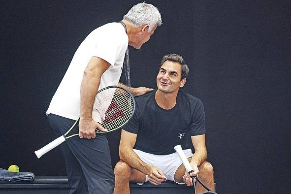 Federer junto a Apostolos Tsitsipas, padre del tenista griego Stefanos Tsitsipas, durante el entrenamiento previo al juego.