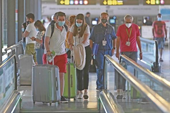 Varios turistas caminan por la terminal 4 del aeropuerto Adolfo Suárez Madrid Barajas..