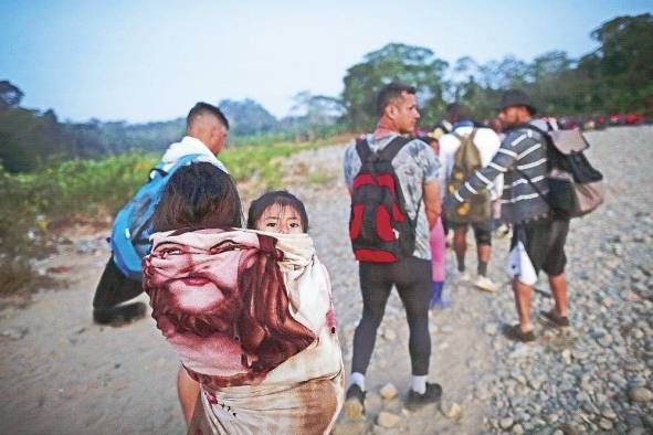 Adultos y niños migrantes hacen fila en la comunidad de Bajo Chiquito, Metetí, Panamá.