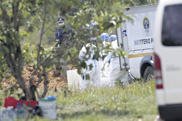 Trabajadores forenses bajan de los vehículos los cuerpos de migrantes fallecidos en un accidente de autobús el pasado mes de febrero, hoy en David.