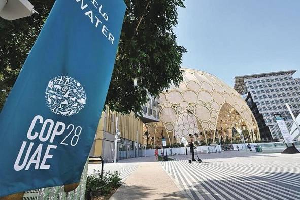 Personas caminando a las afueras de las instalaciones de la COP28.