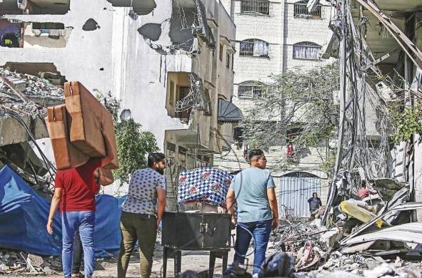 Ciudadanos cargan sus pertenencias mientras evacúan la ciudad de Gaza, en medio de un aumento de las operaciones militares.