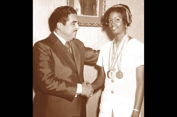 Margarita Martínez recibe un reconocimiento del gerente de la Zona Libre, Roberto Puello, luego de su participación en los juegos de Santo Domingo en 1974.