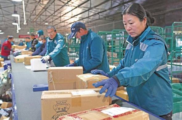 Los trabajadores clasifican paquetes para su entrega antes del festival de compras del “Día de los Solteros” en un centro logístico en Zouping, en la provincia oriental china de Shandong.