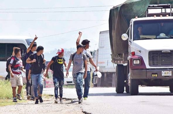 Un grupo de ciudadanos hondureños pide ayuda a un camionero para seguir su camino en el departamento de Santa Bárbara (Honduras).