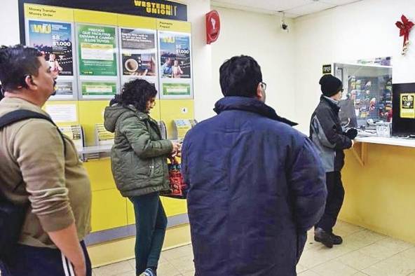 Varias personas esperan su turno para enviar dinero.