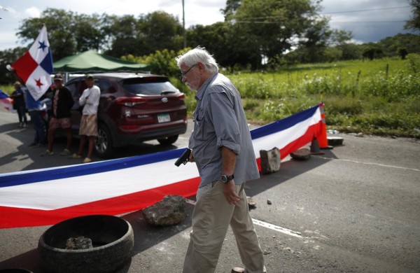 Un hombre sostiene un arma en medio de un bloqueo de docentes en la vía Panamericana hoy, en Chame (Panamá)
