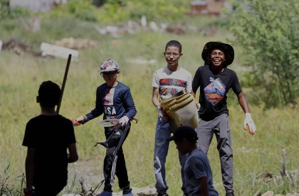 Personas recolectan basuras del Caño Martín Peña hoy, durante el Día Internacional de Limpieza de Costas, en San Juan (Puerto Rico).