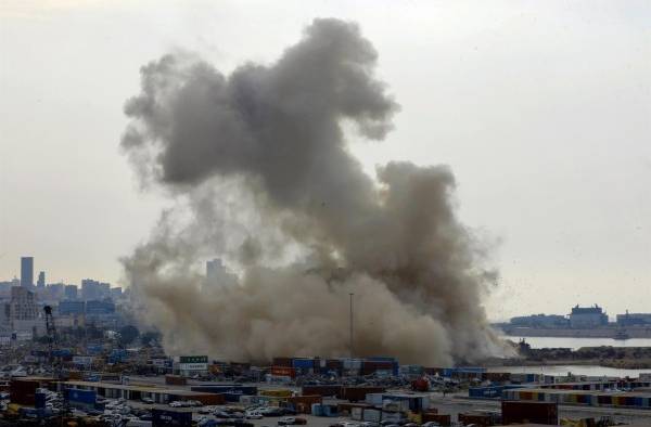 Nube de polvo al derribarse este jueves parte de las ruinas de los silos de grano afectados por la explosión de hace dos años en el puerto de Beirut.