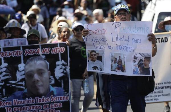 Una mujer muestra un cartel con fotografías de una joven y el pedido de su libertad, durante una marcha de familiares de detenidos