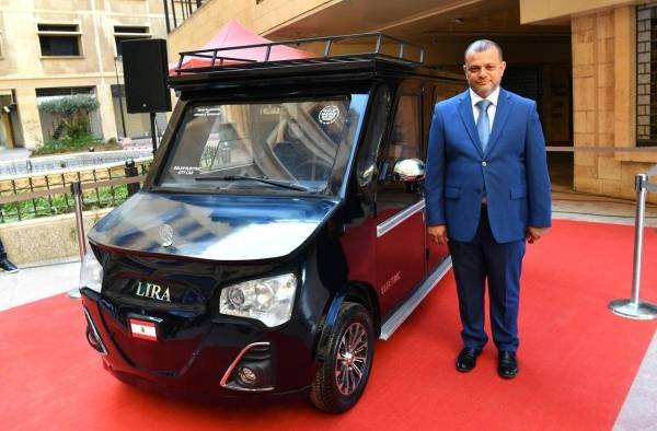 El libanés Hisham Houssami posa junto a su prototipo del Lira, un nuevo coche híbrido que funciona con una mezcla de electricidad y energía solar.